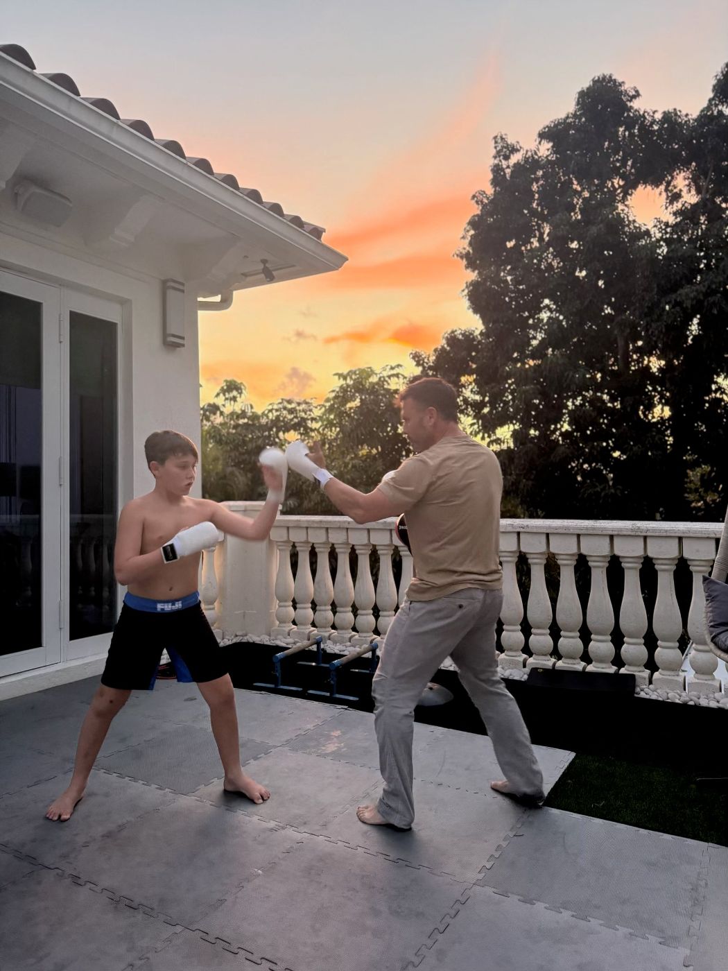 Dr. Allan Stewart boxing with his son at sunset
