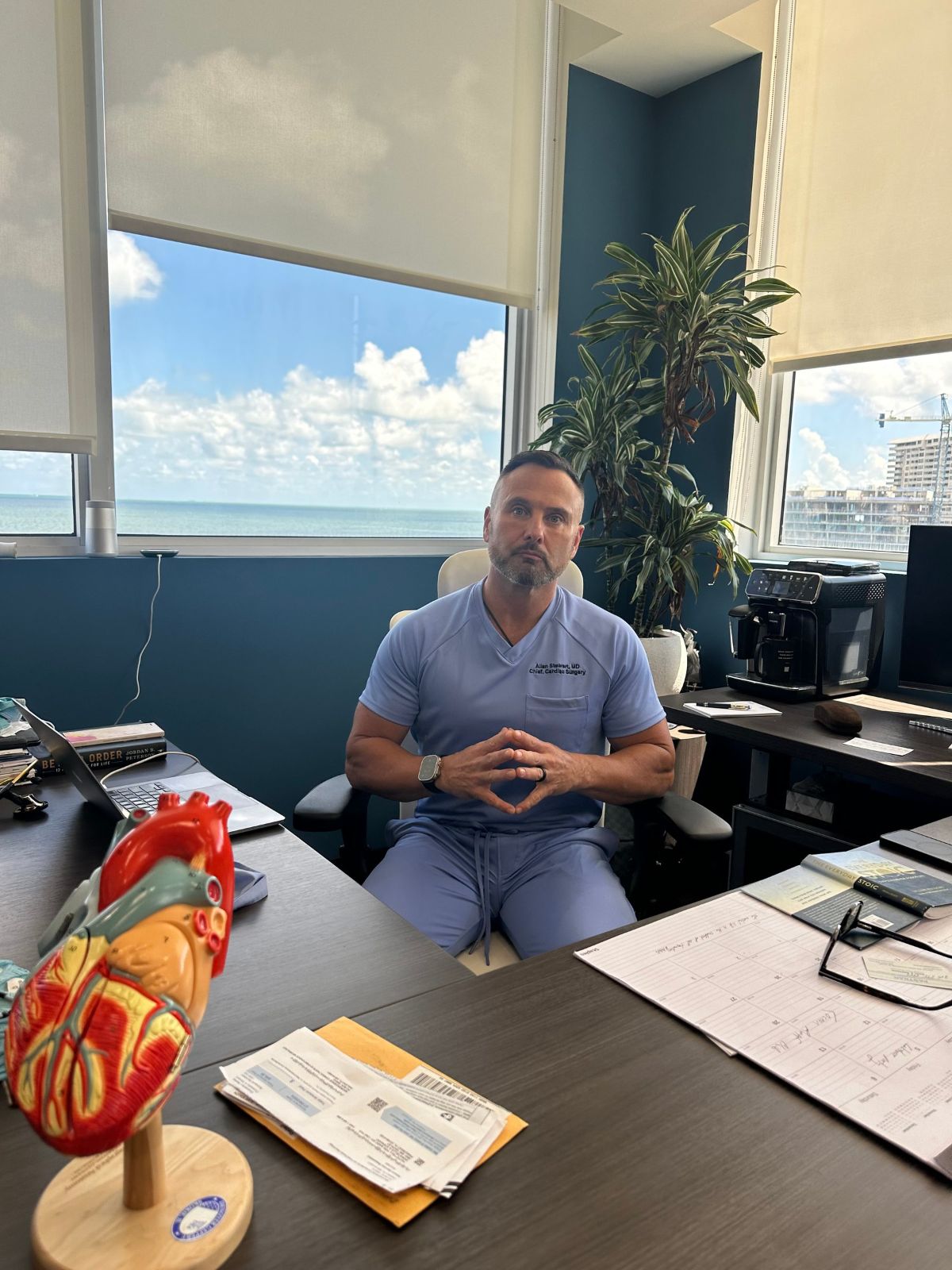 Dr. Allan Stewart at his desk with a model of the heart
