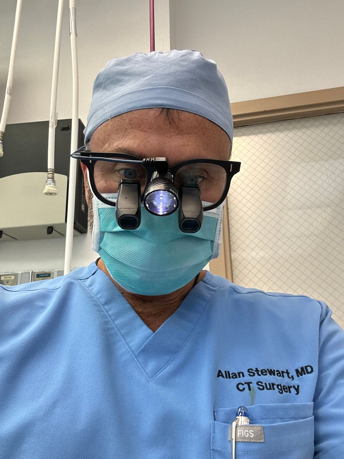 Dr. Allan Stewart in the operating room wearing surgical loupes